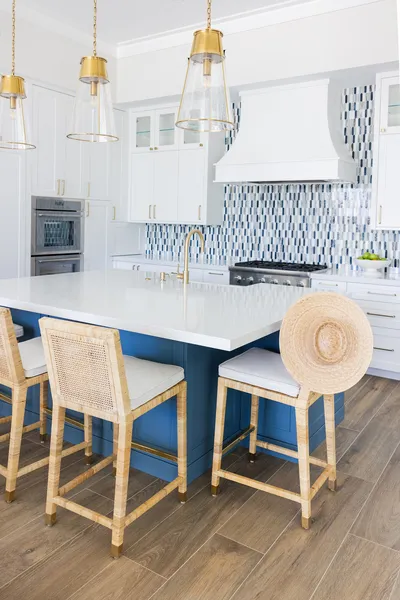 Featuring crisp white and blue cabinetry, this kitchen peninsula provides ample workspace and seating, perfectly blending practicality with aesthetic appeal.
