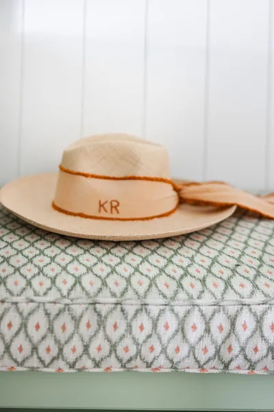 A stylish hat rests on a textured cushion, showcasing personal touches and thoughtful design elements that enhance the relaxed coastal vibe throughout the home.