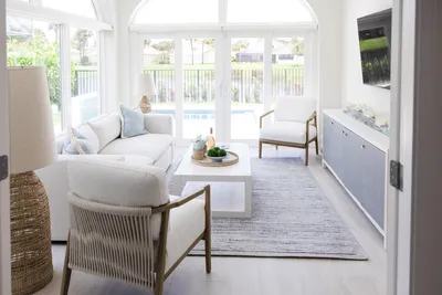 This sunlit lounge combines cozy seating and plentiful natural light. The soothing palette and outdoor views make it an ideal space for relaxation and leisure.